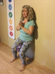 Yoga chair pose at wall for strength